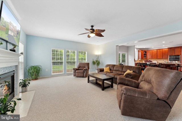 living room featuring ceiling fan, a fireplace with flush hearth, baseboards, light colored carpet, and recessed lighting