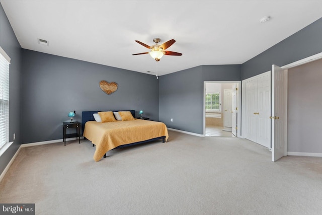 carpeted bedroom with baseboards, ensuite bathroom, and a ceiling fan