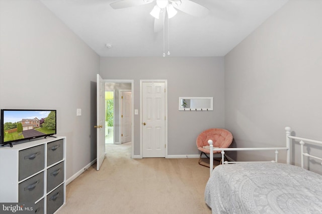 bedroom featuring light carpet, baseboards, and ceiling fan