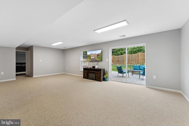 unfurnished living room featuring carpet and baseboards