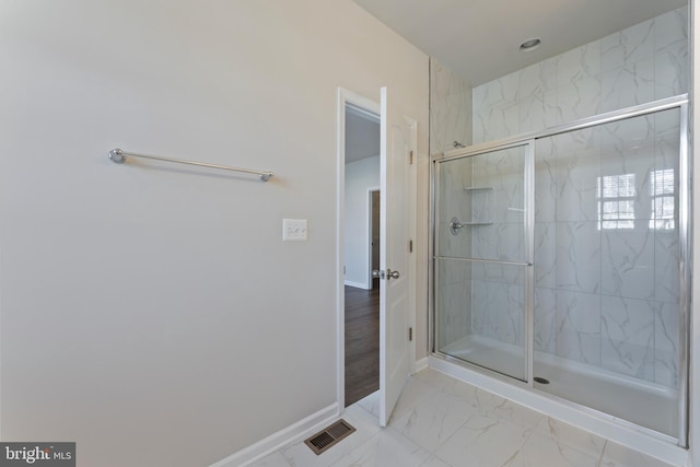 full bathroom featuring baseboards, a marble finish shower, and marble finish floors