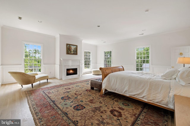 1129 Delaplane Grade Rd, Upperville, VA 20184 - bedroom featuring a decorative wall, ornamental molding, light wood-style flooring, wainscoting, and a high end fireplace