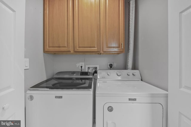 laundry room featuring independent washer and dryer and cabinet space