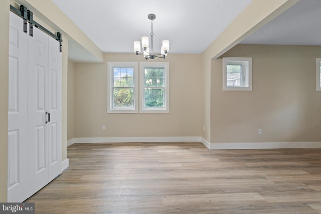 2701 Christopher Ave, Baltimore, MD 21214 - unfurnished dining area featuring a barn door, plenty of natural light, light wood-style floors, and a chandelier