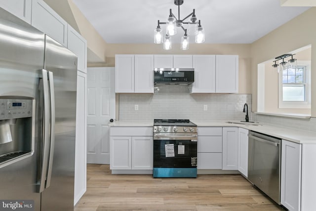 2701 Christopher Ave, Baltimore, MD 21214 - kitchen featuring appliances with stainless steel finishes, light countertops, backsplash, light wood-style flooring, and a chandelier