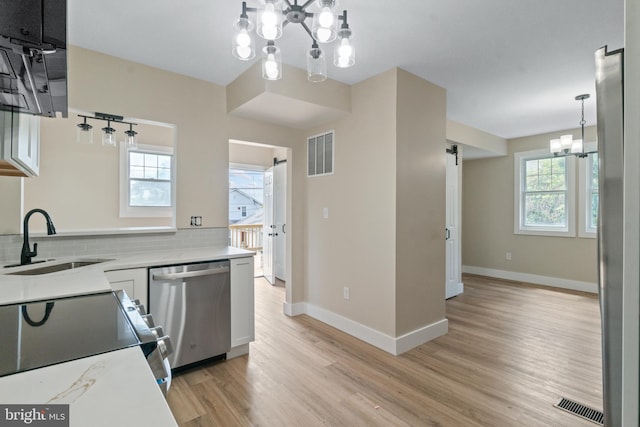 2701 Christopher Ave, Baltimore, MD 21214 - kitchen with dishwasher, a chandelier, range, light wood-style floors, and light countertops