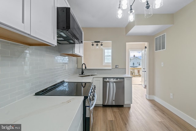 2701 Christopher Ave, Baltimore, MD 21214 - kitchen featuring stainless steel dishwasher, electric range oven, light wood-type flooring, white cabinetry, and tasteful backsplash