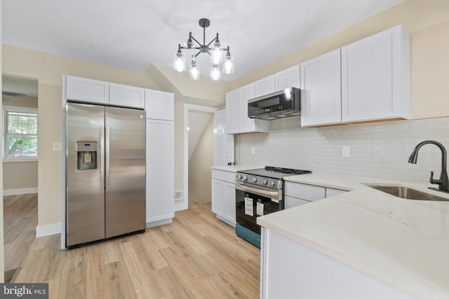2701 Christopher Ave, Baltimore, MD 21214 - kitchen featuring stainless steel appliances, white cabinets, tasteful backsplash, light wood finished floors, and light stone counters