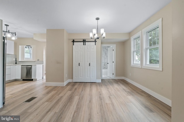 2701 Christopher Ave, Baltimore, MD 21214 - unfurnished dining area featuring a chandelier, a barn door, and light wood-style floors