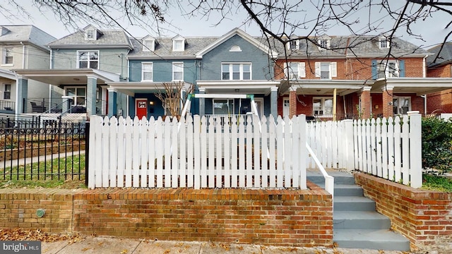 4914 3rd St NW, Washington, DC 20011 - view of front of home with a fenced front yard, a high end roof, covered porch, and brick siding