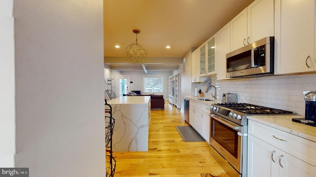 4914 3rd St NW, Washington, DC 20011 - kitchen featuring light wood finished floors, white cabinetry, appliances with stainless steel finishes, decorative backsplash, and recessed lighting