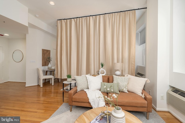 living area featuring baseboards, light wood finished floors, recessed lighting, and a wall mounted AC