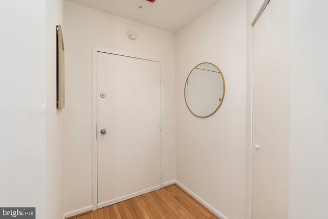 doorway to outside with baseboards and light wood-type flooring
