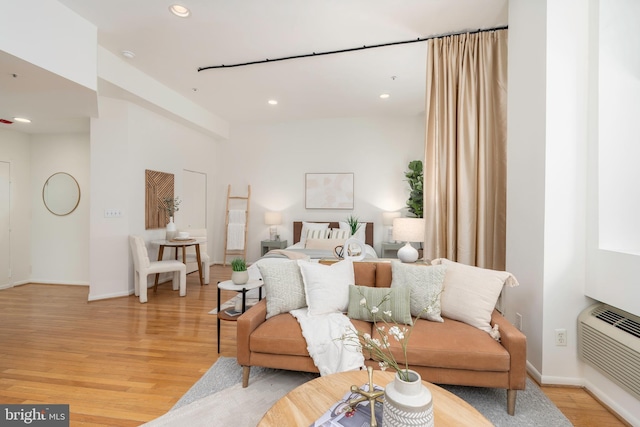 bedroom featuring light wood-type flooring, baseboards, a wall unit AC, and recessed lighting