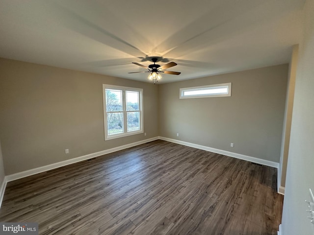 spare room featuring dark wood-type flooring, baseboards, and ceiling fan