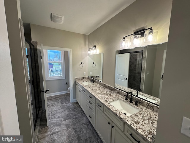 bathroom featuring toilet, a shower stall, and a sink