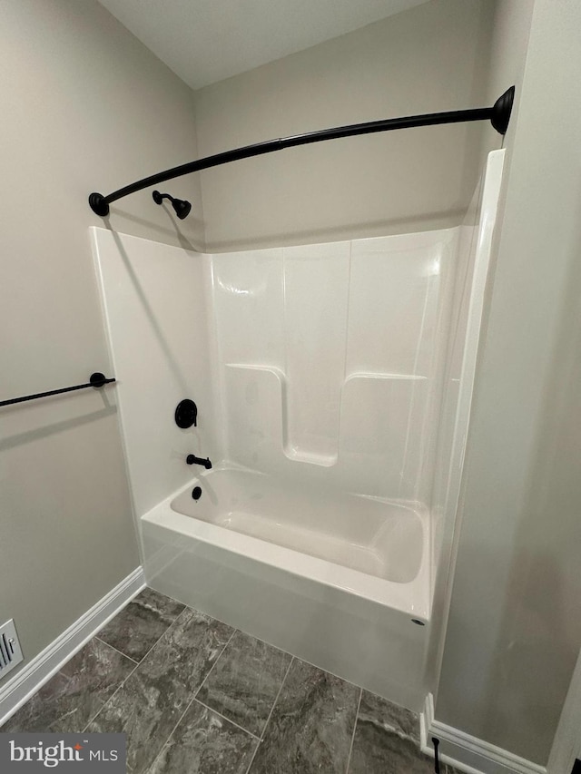 full bathroom with marble finish floor, baseboards, and shower / bathing tub combination