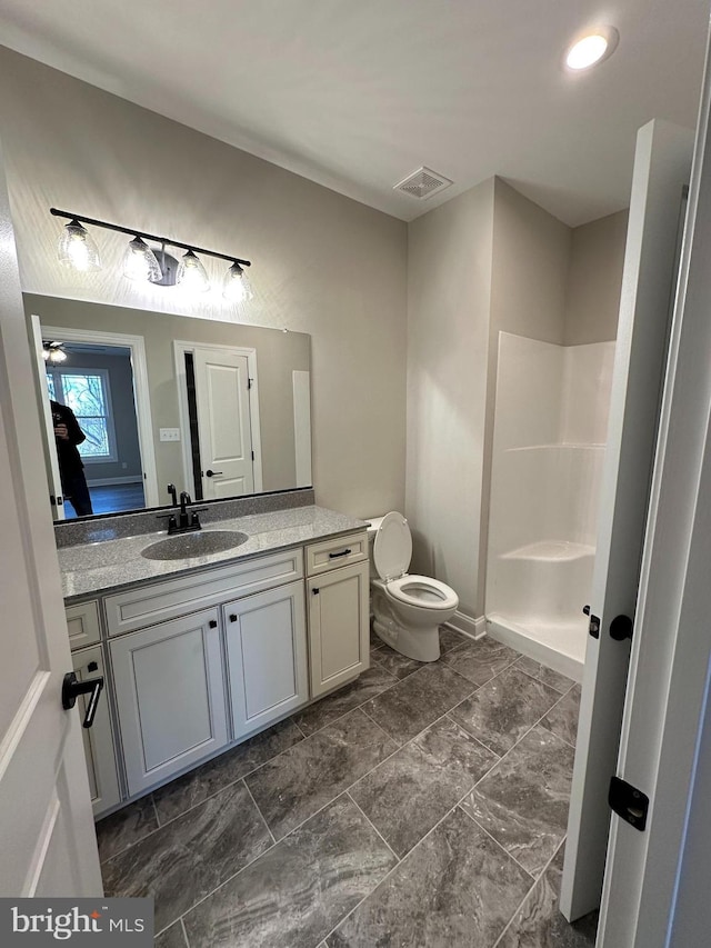 bathroom featuring a shower, toilet, vanity, and visible vents
