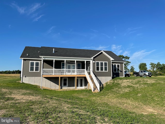 back of property with a yard, stairway, a wooden deck, and a sunroom