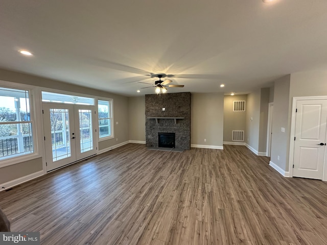 unfurnished living room with ceiling fan, french doors, visible vents, and wood finished floors