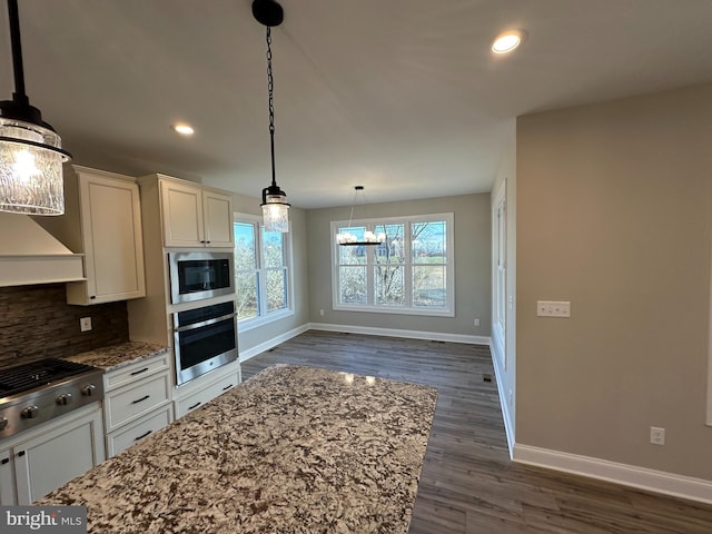 kitchen featuring dark wood-type flooring, recessed lighting, light stone countertops, baseboards, and appliances with stainless steel finishes