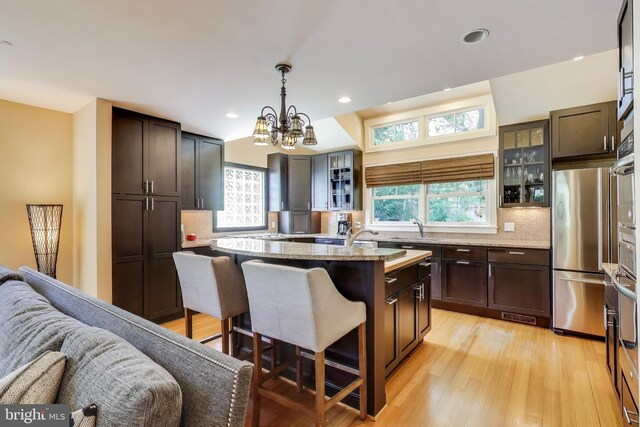3906 Halsey St, Kensington, MD 20895 - kitchen featuring freestanding refrigerator, a kitchen breakfast bar, a sink, decorative backsplash, and recessed lighting