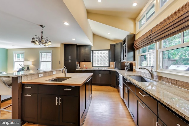 3906 Halsey St, Kensington, MD 20895 - kitchen with a sink, wood counters, a center island with sink, recessed lighting, and pendant lighting