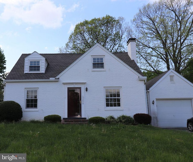 view of front of house featuring a chimney, a front yard, and brick siding