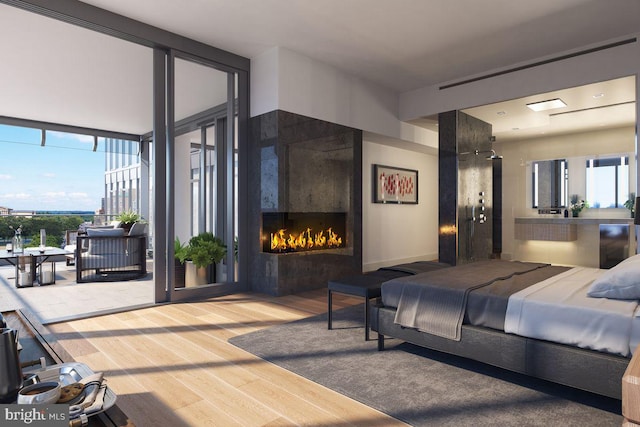bedroom with a lit fireplace, access to exterior, and wood finished floors
