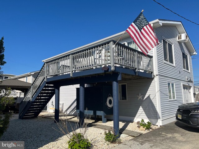 view of front of house featuring a deck, stairs, and a wall unit AC
