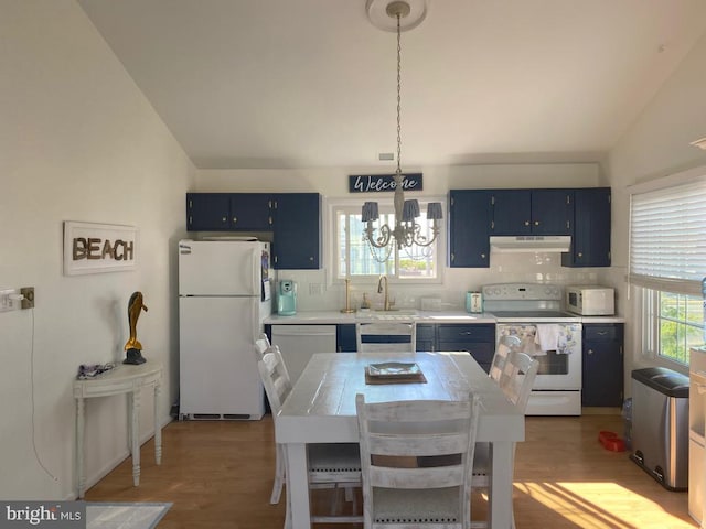kitchen with under cabinet range hood, wood finished floors, blue cabinets, and white appliances