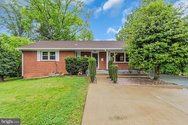single story home with a shingled roof, brick siding, and a front lawn