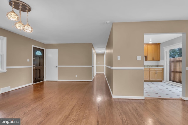 interior space featuring light wood finished floors, baseboards, and visible vents