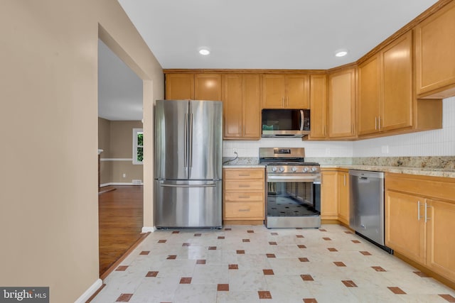 kitchen with stainless steel appliances, decorative backsplash, baseboards, and recessed lighting