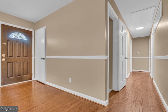 foyer entrance with wood finished floors and baseboards