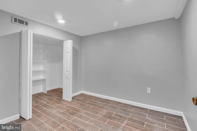 unfurnished bedroom featuring a closet, wood finished floors, visible vents, recessed lighting, and baseboards
