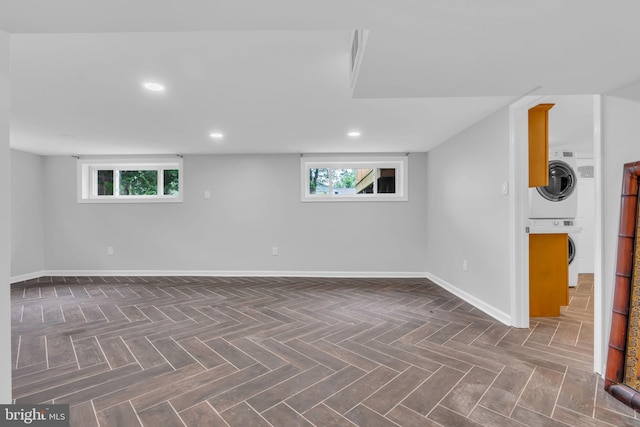 below grade area featuring stacked washer and clothes dryer, plenty of natural light, baseboards, and recessed lighting