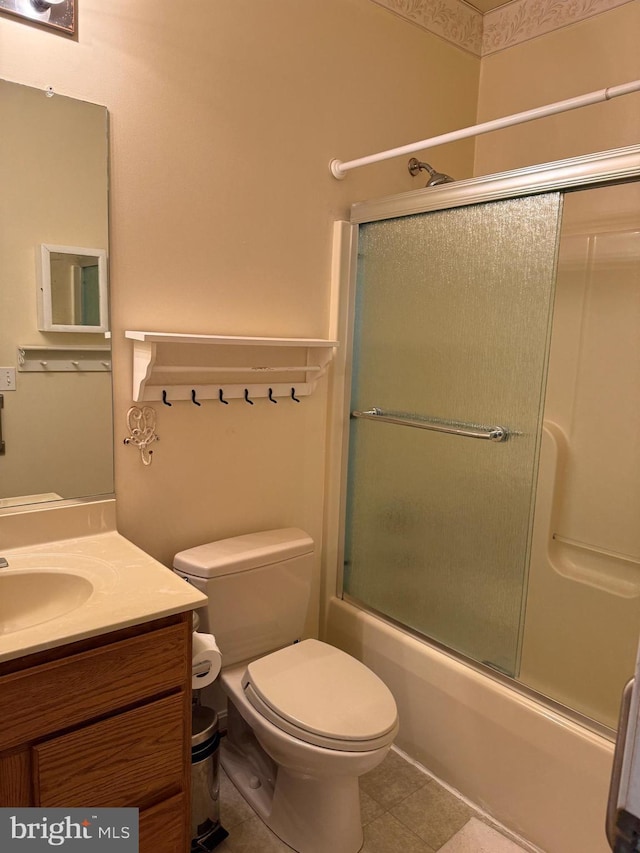 full bathroom featuring tile patterned flooring, vanity, toilet, and shower / bath combination with glass door