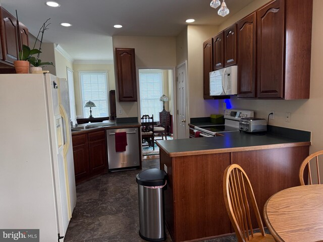 kitchen featuring white appliances, crown molding, a peninsula, dark countertops, and recessed lighting