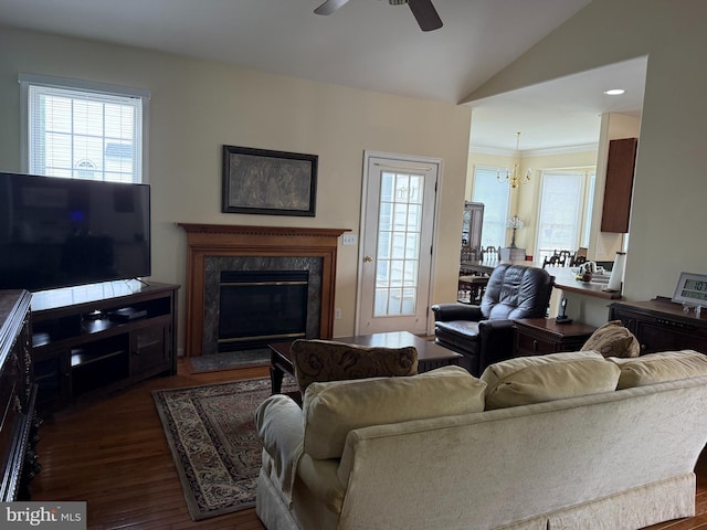 living room with ceiling fan, dark wood-type flooring, vaulted ceiling, and a fireplace