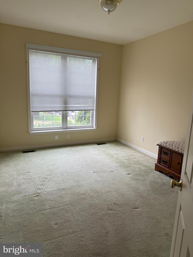spare room featuring carpet flooring and baseboards