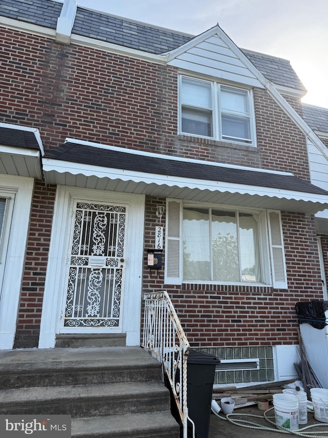 view of exterior entry featuring brick siding