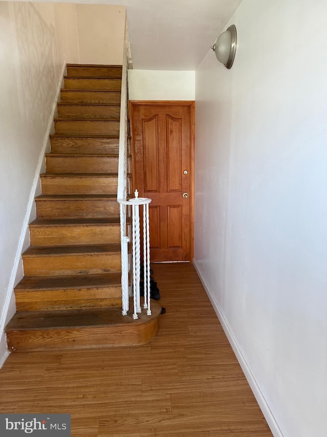 stairway with baseboards and wood finished floors