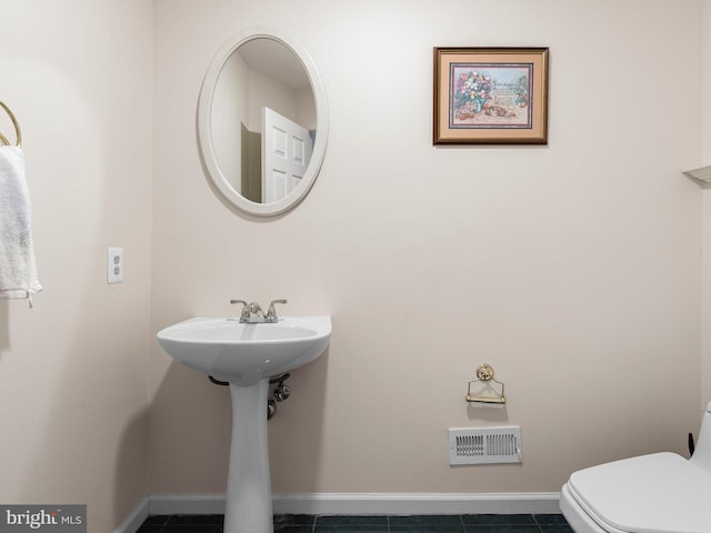 half bath featuring toilet, baseboards, and visible vents