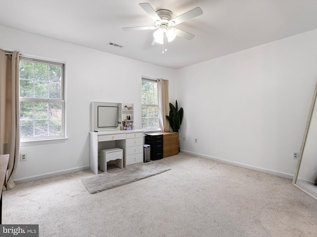 unfurnished office with visible vents, baseboards, ceiling fan, and light carpet