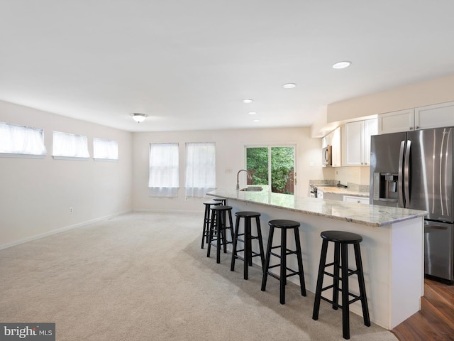 kitchen featuring a wealth of natural light, appliances with stainless steel finishes, a spacious island, and a breakfast bar