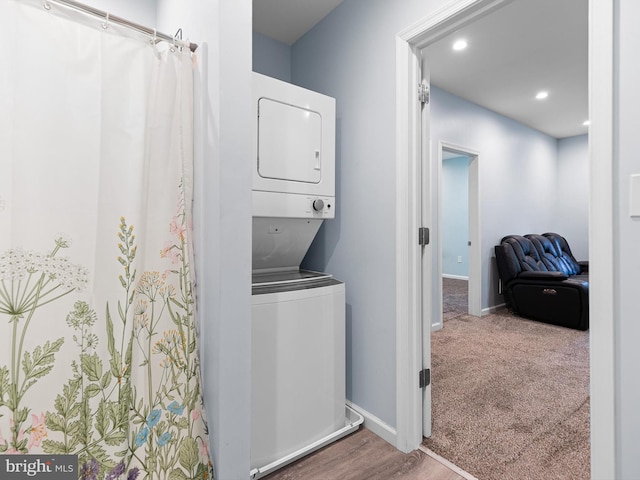 laundry area with laundry area, stacked washer and clothes dryer, baseboards, and recessed lighting