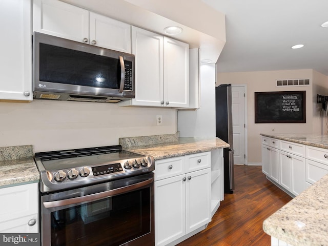 kitchen with stainless steel appliances, white cabinetry, dark wood-style floors, and visible vents