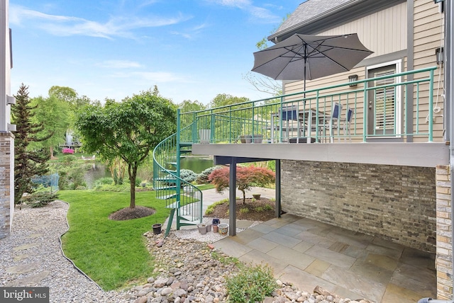 view of grassy yard with stairs and a patio