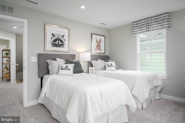 bedroom with baseboards, visible vents, and light carpet